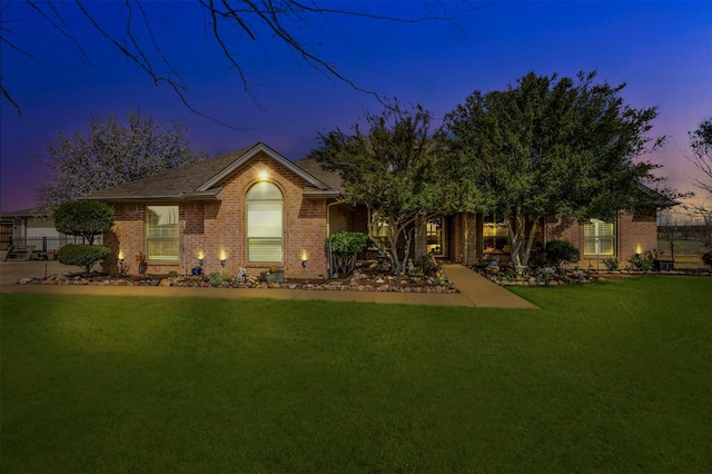 view of front of property with a front lawn and brick siding