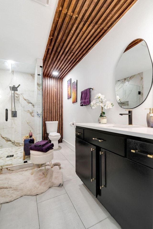 full bathroom featuring vanity, toilet, tile patterned flooring, and a marble finish shower