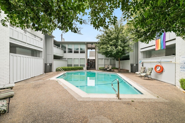 community pool featuring stairway and a patio area