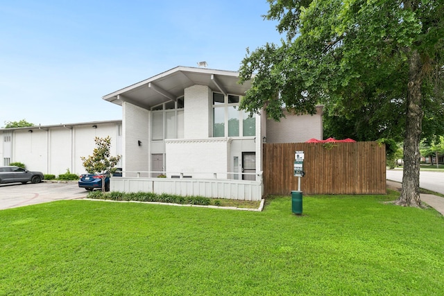 view of front of house featuring brick siding and a front yard