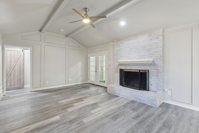 4018 Tobin Trl, Rowlett, TX 75088 - unfurnished living room featuring a decorative wall, a ceiling fan, wood finished floors, and a fireplace