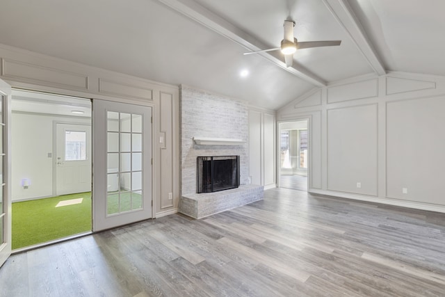 4018 Tobin Trl, Rowlett, TX 75088 - unfurnished living room featuring a decorative wall, a brick fireplace, ceiling fan, and wood finished floors