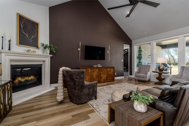 2652 Kessler Dr, Celina, TX 75009 - living area with a glass covered fireplace, wood finished floors, high vaulted ceiling, and ceiling fan