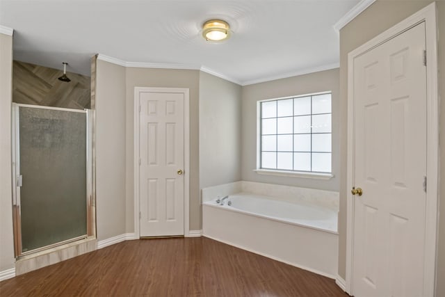 bathroom featuring a shower stall, wood finished floors, a bath, crown molding, and baseboards