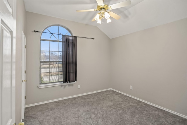 carpeted spare room with vaulted ceiling, baseboards, and ceiling fan