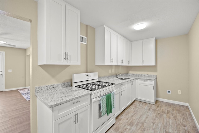 399 E College St, Alba, TX 75410 - kitchen with a sink, white cabinetry, light wood-style flooring, and white range with gas cooktop