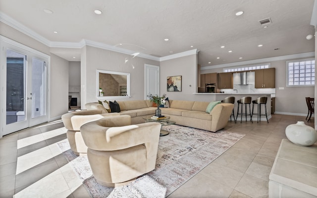 kitchen with wall chimney range hood, a sink, stainless steel appliances, light tile patterned floors, and visible vents