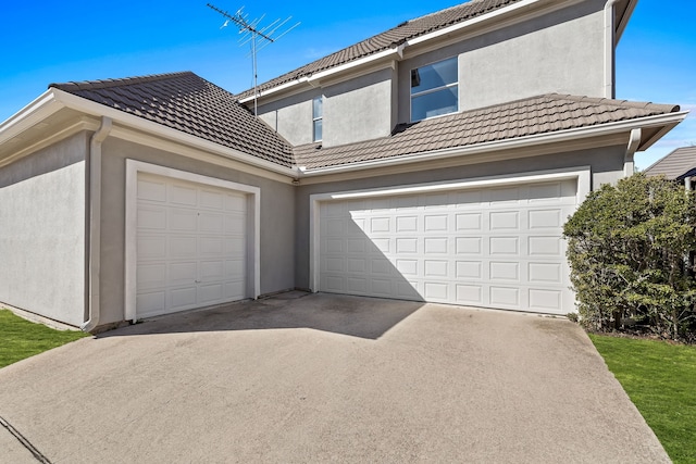 view of front of home featuring driveway, a tile roof, and stucco siding