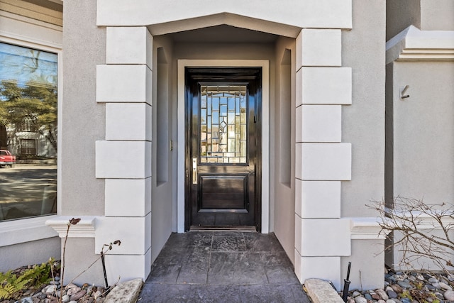 entrance to property featuring stucco siding