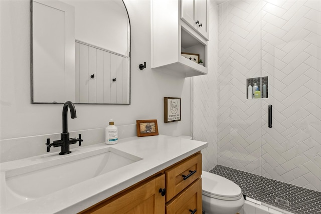 bathroom with a stall shower, toilet, and vanity