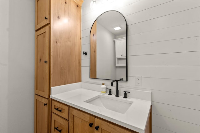 bathroom featuring vanity and wooden walls
