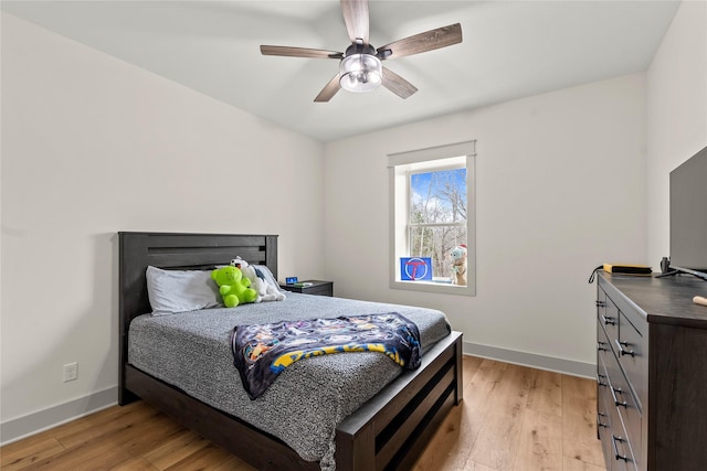 bedroom featuring ceiling fan, light wood-type flooring, and baseboards