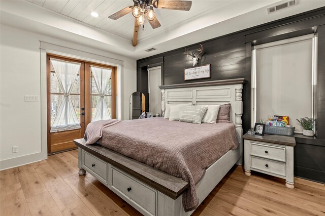 bedroom with visible vents, baseboards, light wood-style floors, and french doors