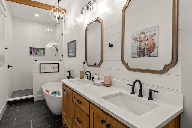 full bathroom with an inviting chandelier, a soaking tub, a walk in shower, and a sink