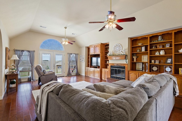living area with visible vents, a brick fireplace, vaulted ceiling, dark wood-style floors, and a ceiling fan