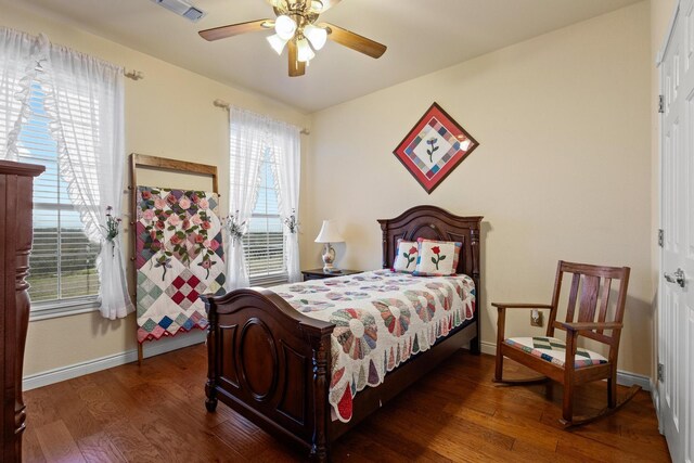 bedroom featuring visible vents, baseboards, wood finished floors, and a ceiling fan