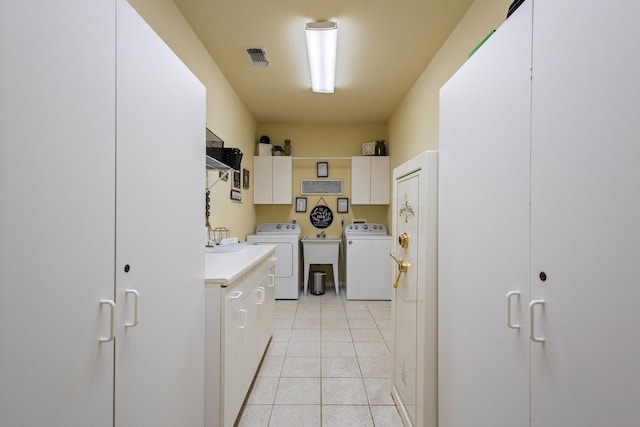 washroom featuring light tile patterned flooring, visible vents, cabinet space, and separate washer and dryer