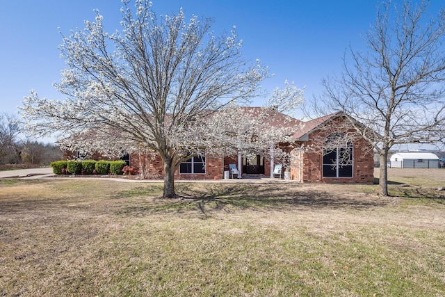 view of front of property featuring a front lawn and brick siding