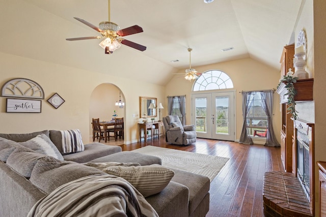living area featuring visible vents, arched walkways, ceiling fan, hardwood / wood-style flooring, and vaulted ceiling