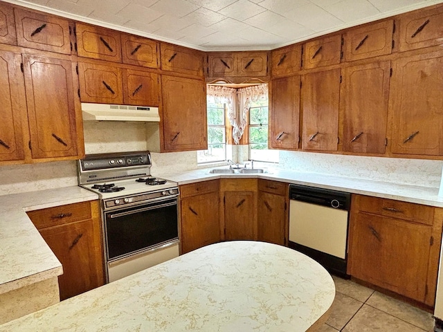 2431 N Jefferson, Mount Pleasant, TX 75455 - kitchen featuring gas range, under cabinet range hood, dishwasher, a sink, and brown cabinetry