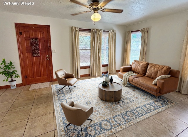 2431 N Jefferson, Mount Pleasant, TX 75455 - living room featuring a textured ceiling, ceiling fan, light tile patterned floors, and baseboards