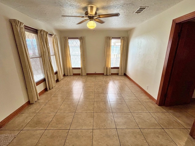 2431 N Jefferson, Mount Pleasant, TX 75455 - spare room with a textured ceiling, a ceiling fan, light tile patterned flooring, and baseboards