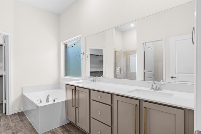 full bathroom with a shower stall, a garden tub, wood tiled floor, and a sink