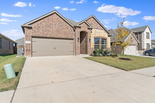 view of front of house with a front lawn, concrete driveway, brick siding, and a garage