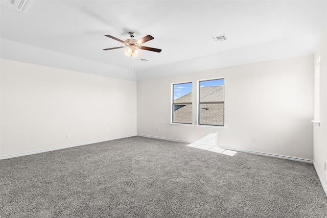 empty room with carpet flooring, a ceiling fan, visible vents, and baseboards