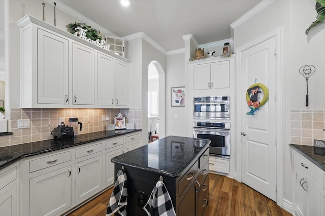 12265 Indian Creek Dr, Fort Worth, TX 76179 - kitchen featuring dark stone countertops, white cabinets, arched walkways, and backsplash