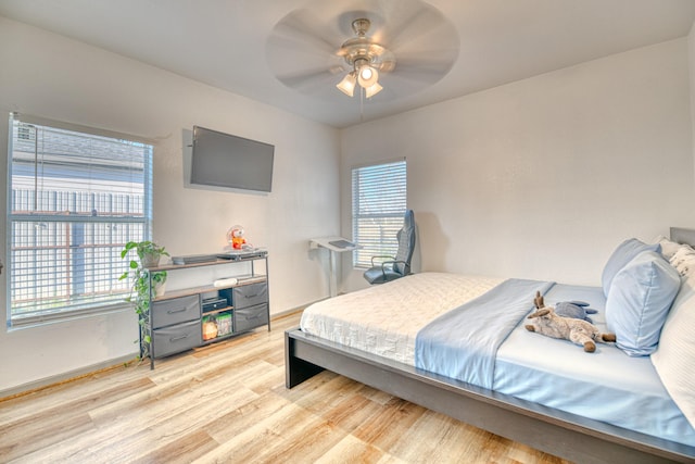 bedroom featuring light wood finished floors, baseboards, and ceiling fan