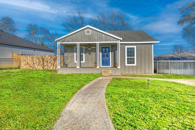 view of front of property with ceiling fan, a porch, a front yard, and fence