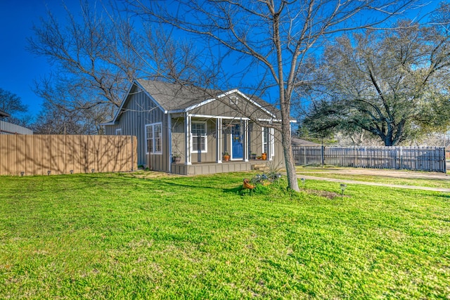view of front of home featuring board and batten siding, a front yard, and fence