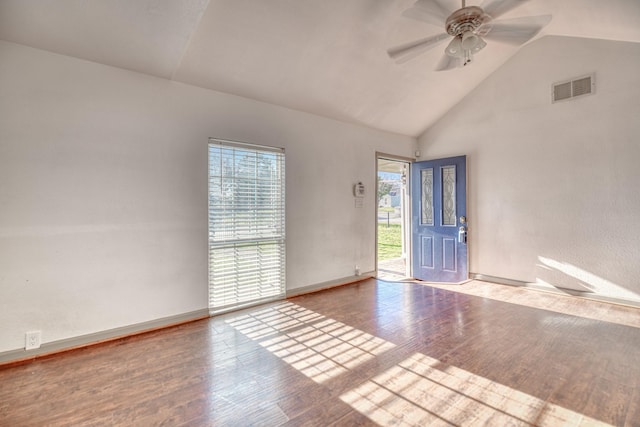 unfurnished room featuring wood finished floors, baseboards, visible vents, high vaulted ceiling, and ceiling fan