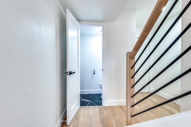 stairs with baseboards and wood finished floors