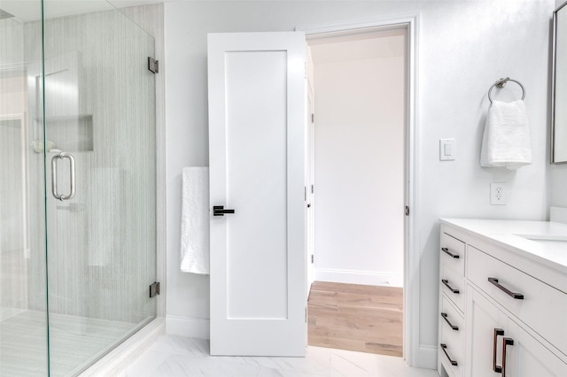 bathroom with vanity, baseboards, and a stall shower