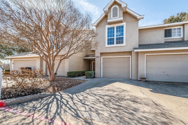 view of front of home with a garage, stucco siding, and driveway