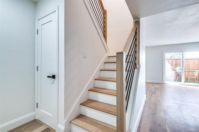stairs featuring baseboards and wood finished floors