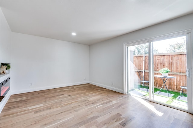 unfurnished living room featuring recessed lighting, baseboards, and light wood-type flooring
