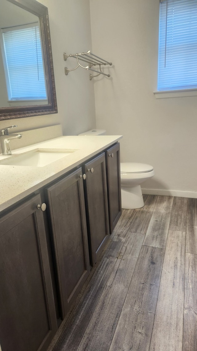 5919 Pleasant Hill Dr, Arlington, TX 76016 - half bath featuring vanity, wood finished floors, toilet, and healthy amount of natural light