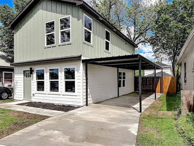 1405 S Freeway Freeway, Fort Worth, TX 76104 - view of front of house featuring fence, board and batten siding, concrete driveway, and an attached carport