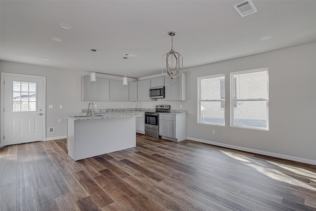 1405 S Freeway Freeway, Fort Worth, TX 76104 - kitchen featuring an island with sink, appliances with stainless steel finishes, a sink, visible vents, and dark wood-type flooring