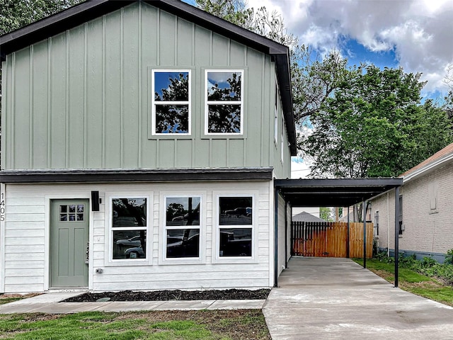 1405 S Freeway Freeway, Fort Worth, TX 76104 - view of front facade featuring concrete driveway, an attached carport, board and batten siding, and fence
