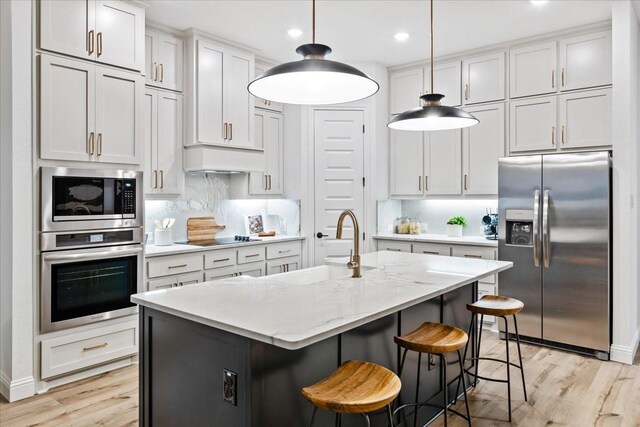 1210 Terrain Ln, Midlothian, TX 76065 - kitchen with appliances with stainless steel finishes, light wood-style flooring, a sink, hanging light fixtures, and recessed lighting