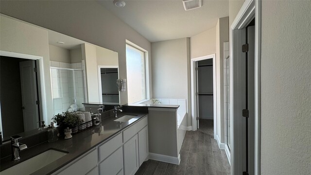 bathroom with a sink, visible vents, a shower stall, and a spacious closet