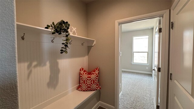 mudroom with baseboards and carpet floors