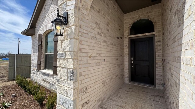 doorway to property featuring brick siding