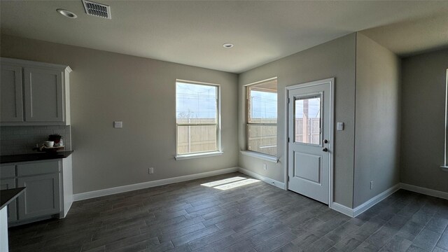 unfurnished dining area featuring recessed lighting, visible vents, baseboards, and dark wood-style flooring