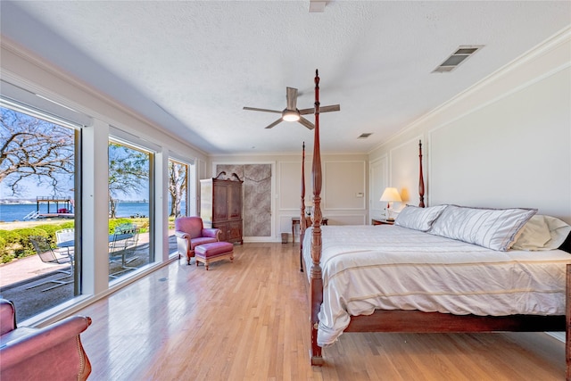 39 Lakeside Dr, Star Harbor, TX 75148 - bedroom with access to exterior, light wood-style flooring, crown molding, a water view, and a textured ceiling