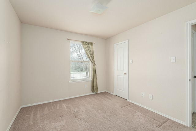 carpeted empty room featuring baseboards